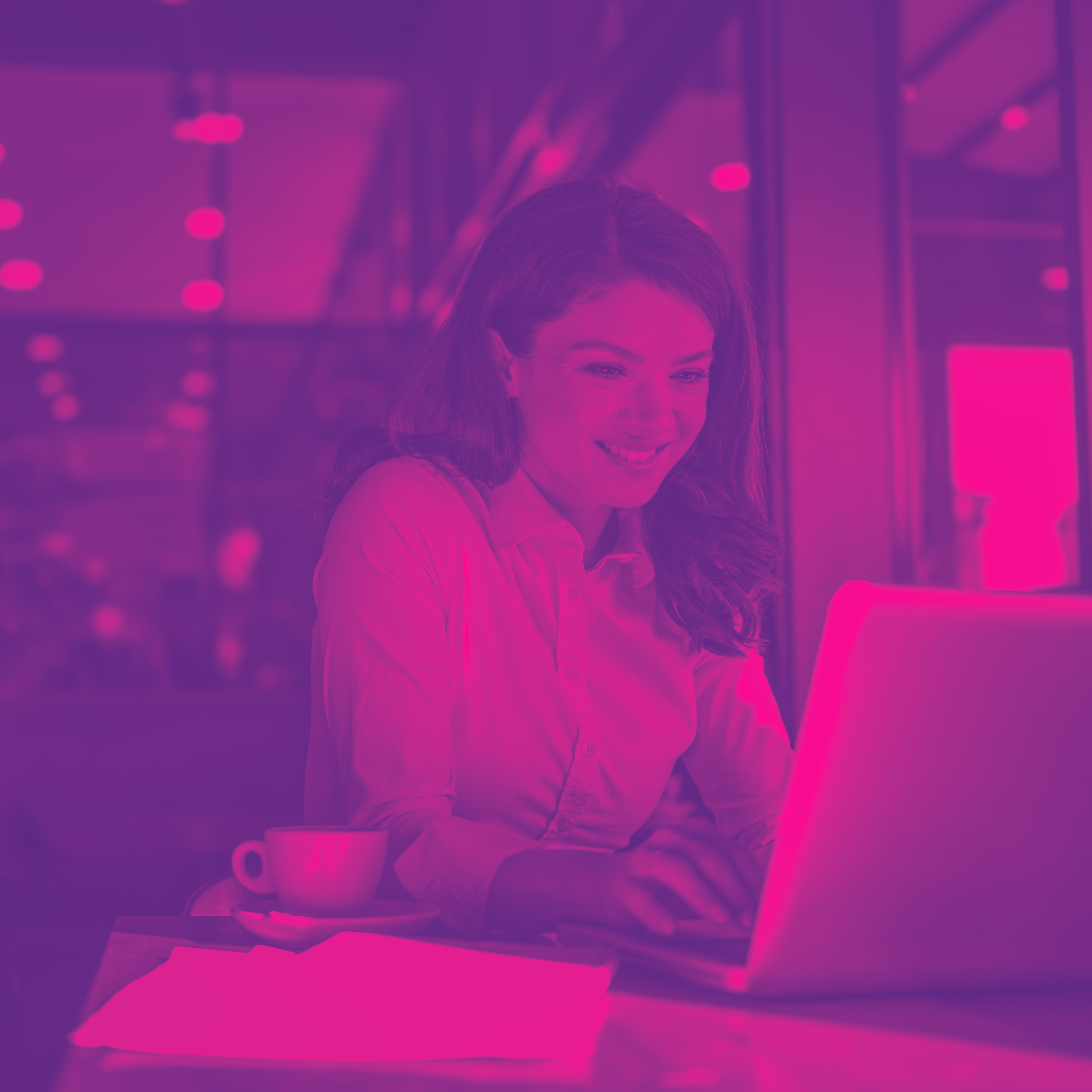 A happy hotel worker using a laptop